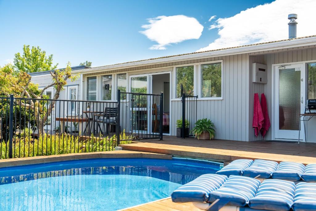 a house with a swimming pool and a patio at Studio Twenty5, Unique Poolside Retreat Near Nelson in Richmond