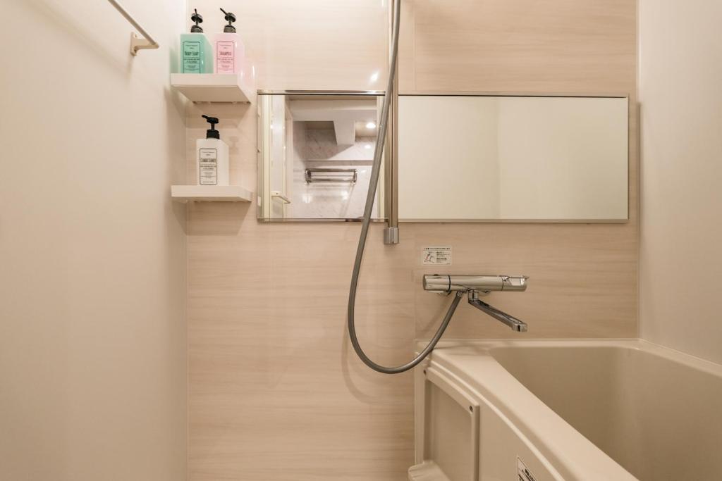 東京にあるShinjuku Yoyogi Hearts Houseのバスルーム(バスタブ、シンク、鏡付)
