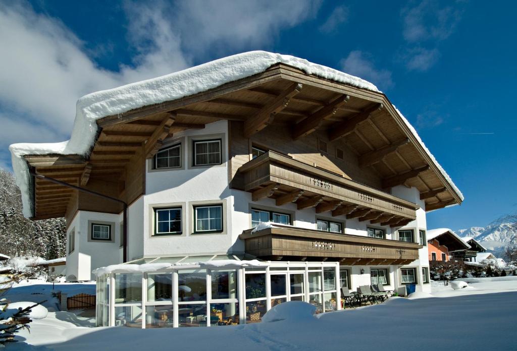 a large building with snow on the ground at Appartements Familie Grundner in Leogang
