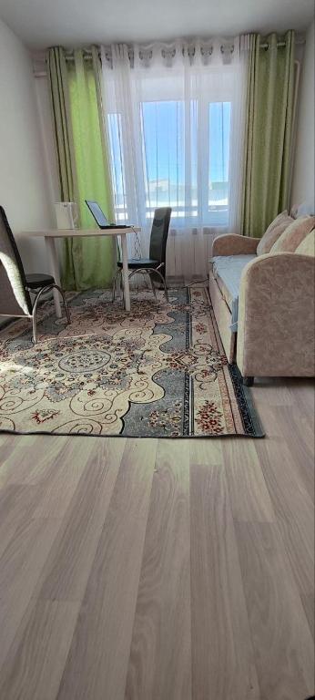 a living room with a couch and a table at Квартира рядом с Караколом in Karakol