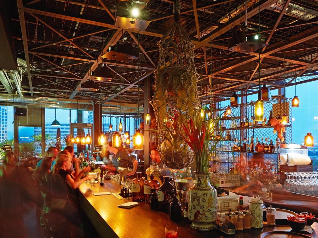 a bar with people sitting at a bar at 25hours Hotel Bikini Berlin in Berlin