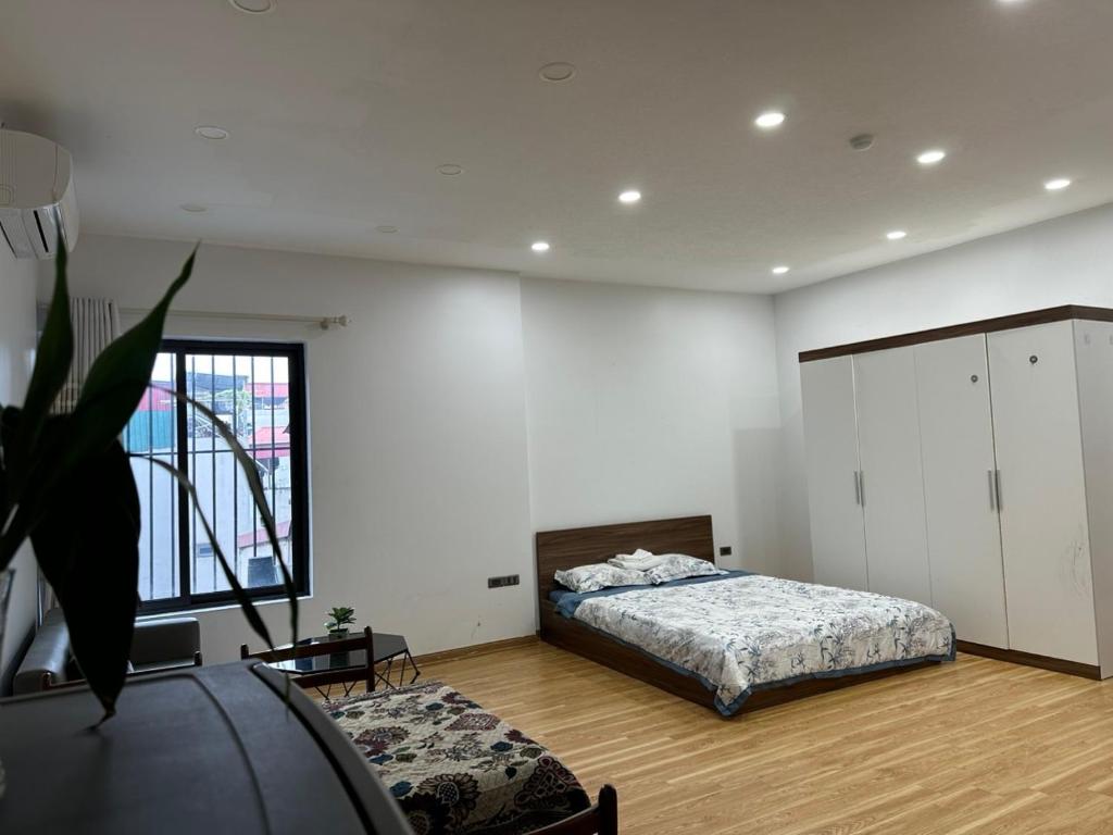 a bedroom with a bed and a large window at MINGO House BA ĐÌNH in Hanoi