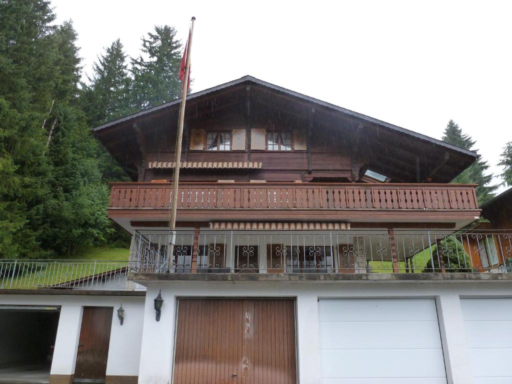 une grande maison avec un balcon et un bâtiment dans l'établissement Alpenrösli, à Schwarzsee