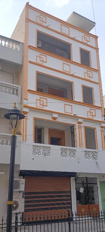 a large building with a balcony and a street light at NKS Service Apartment in Pondicherry