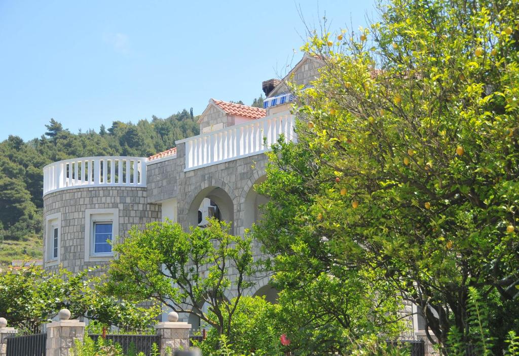 una gran casa de piedra con árboles delante de ella en Villa Mirjana, en Lopud Island