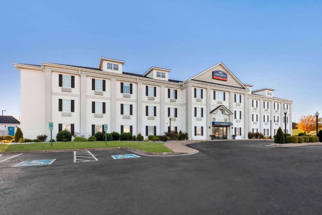 a large white building with a parking lot at Howard Johnson by Wyndham Jackson in Jackson