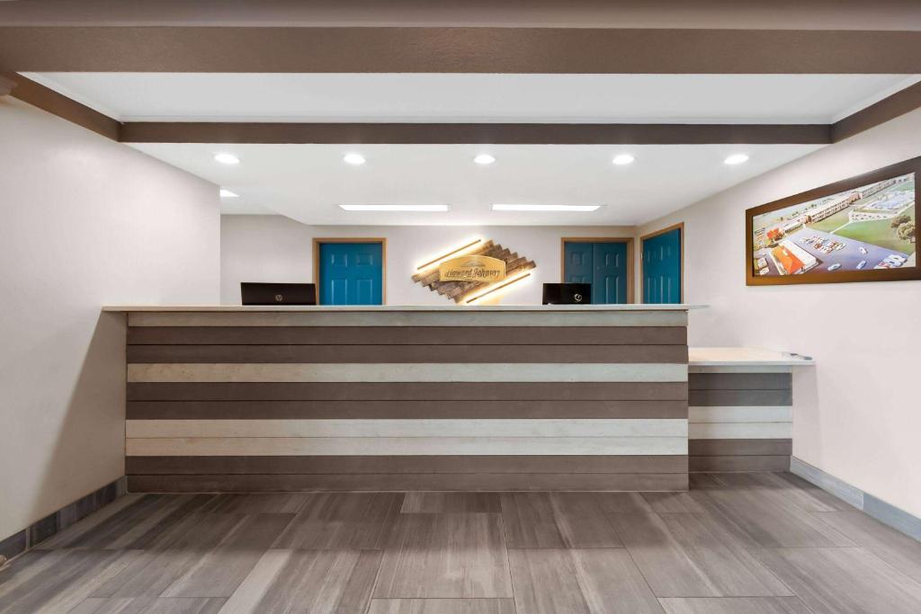 a lobby with a reception counter with blue doors at Howard Johnson by Wyndham Jackson in Jackson