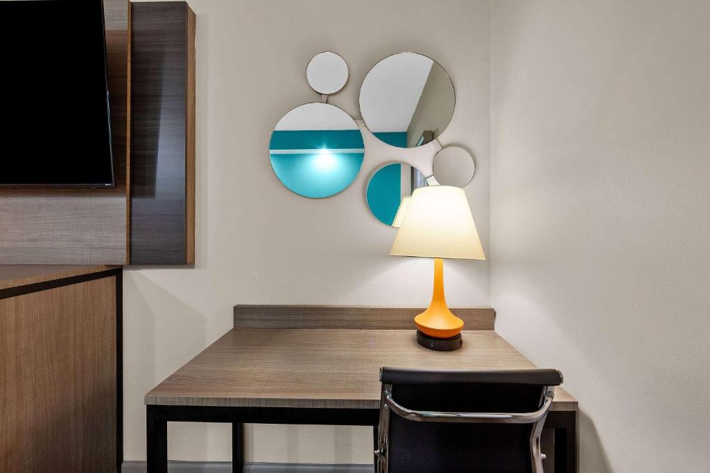 a table with a lamp and a mirror at Howard Johnson by Wyndham Jackson in Jackson