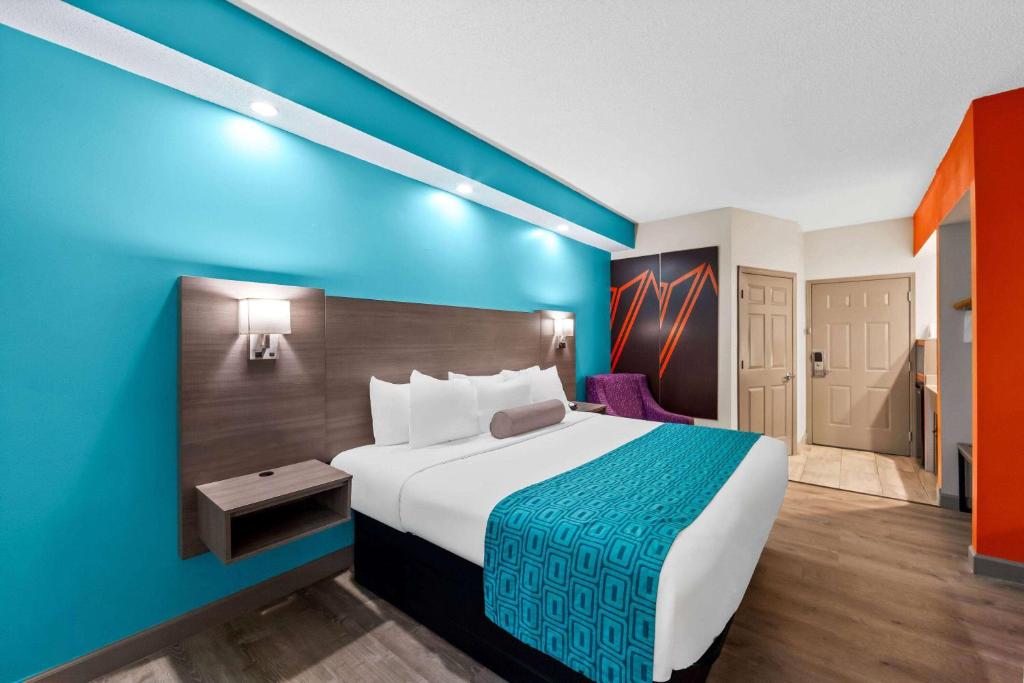 a hotel room with a bed and a blue wall at Howard Johnson by Wyndham Jackson in Jackson