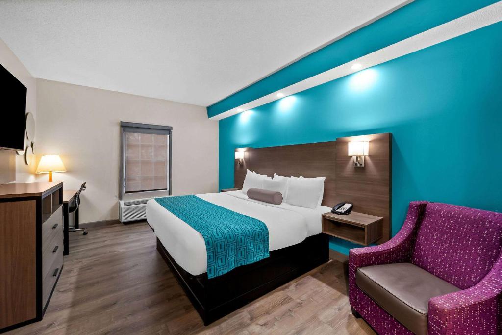 a hotel room with a bed and a chair at Howard Johnson by Wyndham Jackson in Jackson