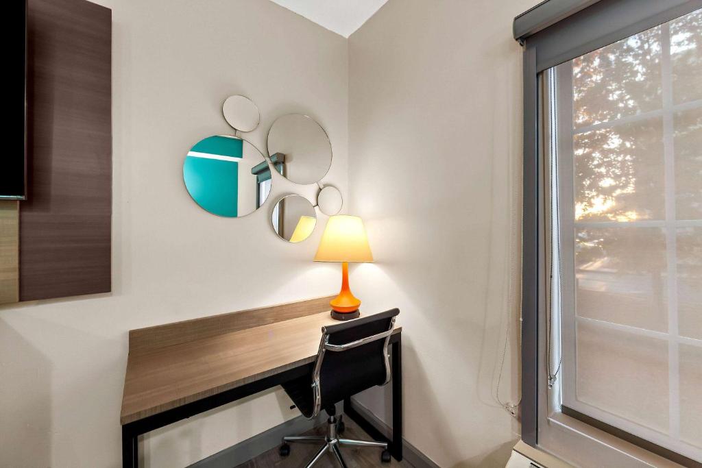 a desk with a lamp and mirrors on a wall at Howard Johnson by Wyndham Jackson in Jackson