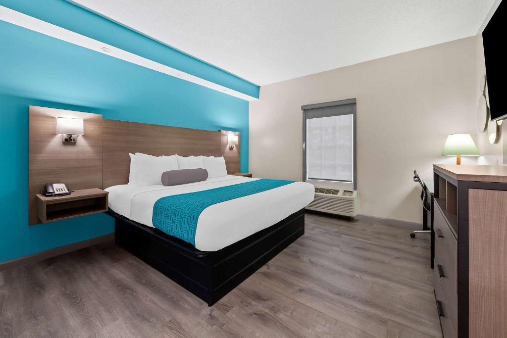 a hotel room with a large bed and a window at Howard Johnson by Wyndham Jackson in Jackson