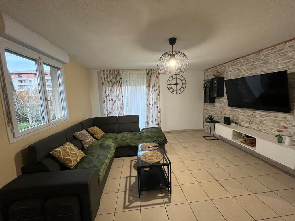 un salon avec un canapé et une télévision à écran plat dans l'établissement Appartement spacieux avec piscine, à Marseille