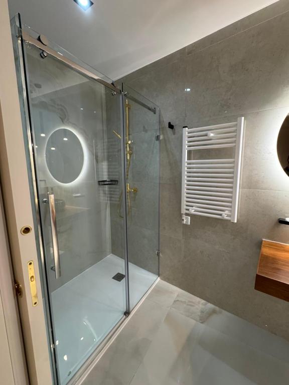 una doccia con una porta in vetro in un bagno di Skyline Soak, Views & Jacuzzi a San Giuliano