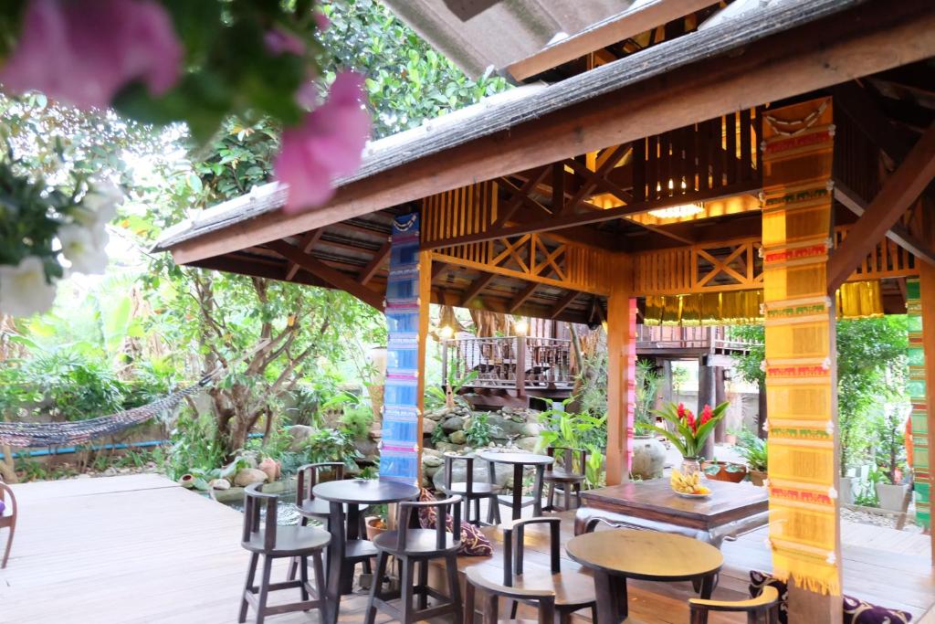 a patio at a restaurant with tables and chairs at Kittawan Home&Gallery in Chiang Mai