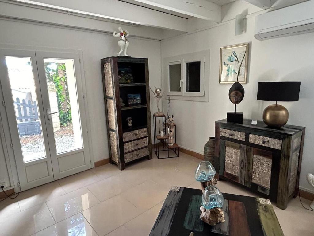 d'un salon avec une table et d'une chambre avec des fenêtres. dans l'établissement Petite Maison de Charme, à Auriol