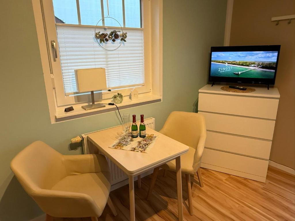 a small dining room with a table and a television at Ferienzimmer/wohnung am Kurstrand, WLAN in Zingst