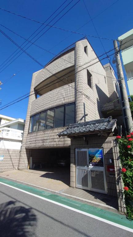 a brick building with a door in front of it at ゲストハウスブルーオーシャン那覇 in Naha
