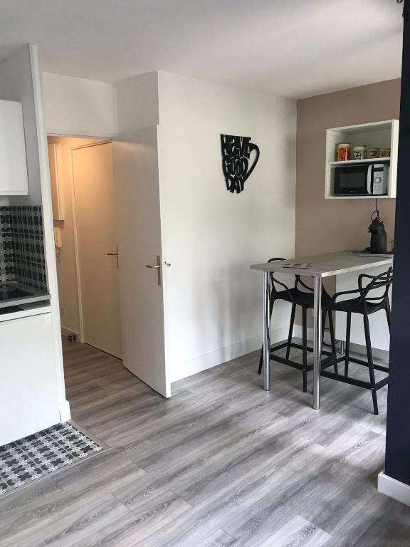 une cuisine et une salle à manger avec une table et des chaises dans l'établissement Charmant studio au bord du lez, à Montpellier