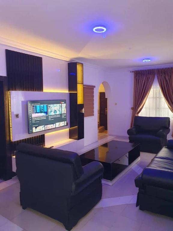 a living room with couches and a flat screen tv at Life Apartment in Aguda