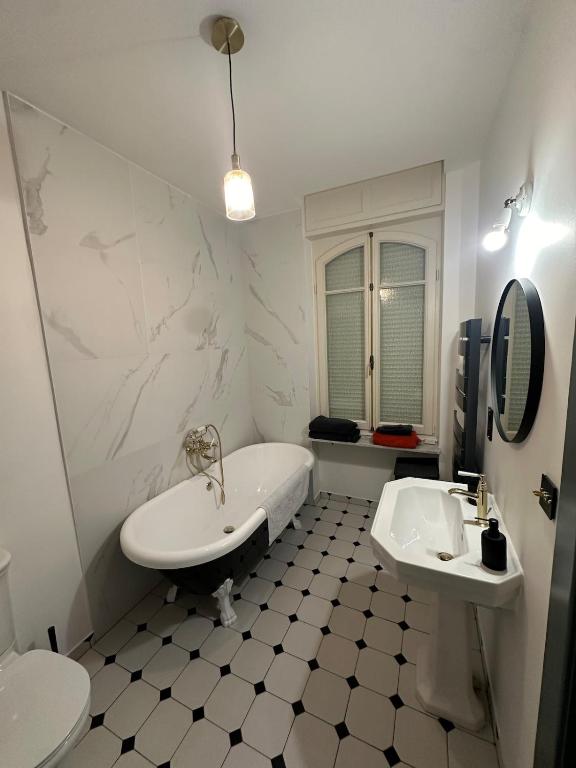 une salle de bain blanche avec une baignoire et un lavabo dans l'établissement Appartement dans Maison de Maître, à Schiltigheim