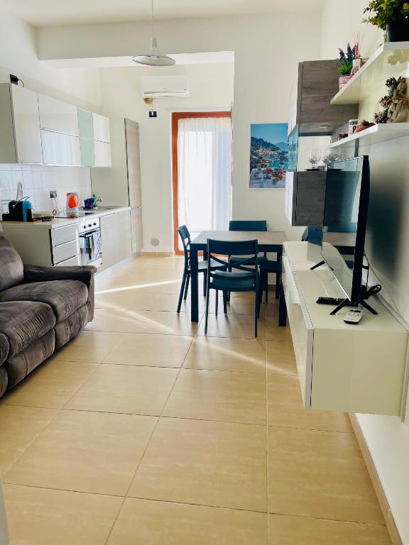 a kitchen and living room with a table with a computer at Casa Adele in Salerno