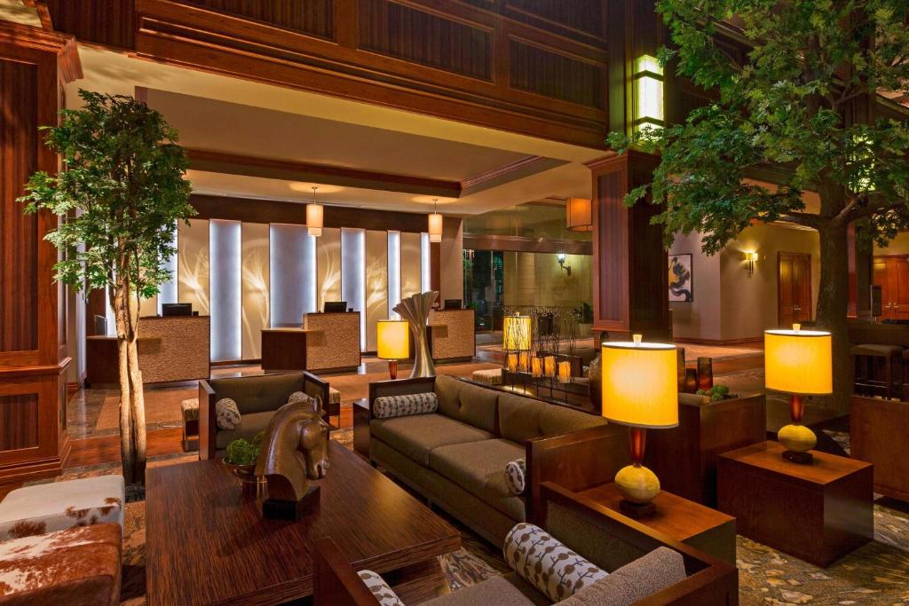 a living room with a couch and chairs and trees at The Westin Houston Downtown in Houston