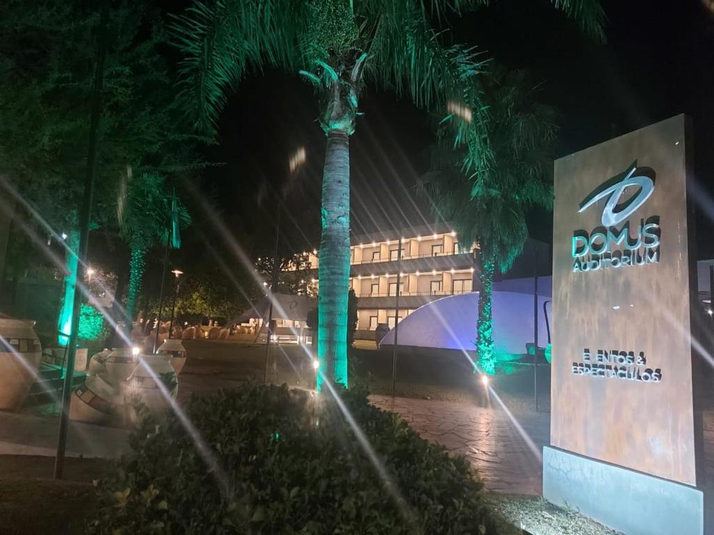 nachts eine Palme vor einem Gebäude in der Unterkunft DOMUS AUDITORIUM in Villa Carlos Paz