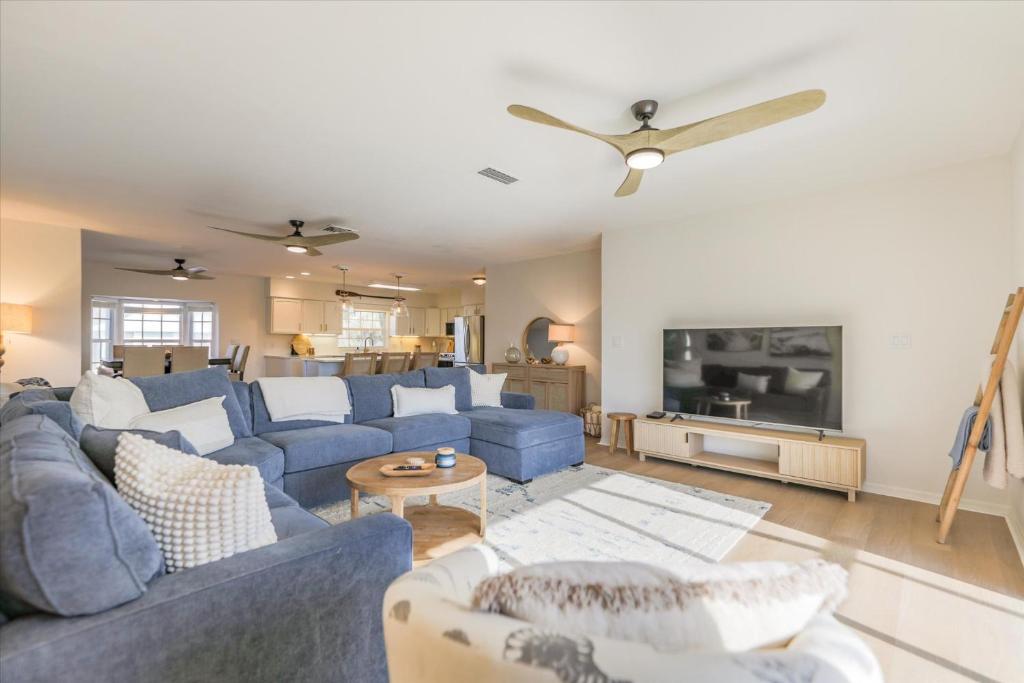 un salon avec des canapés bleus et une télévision dans l'établissement Dock Holiday, à Sanibel