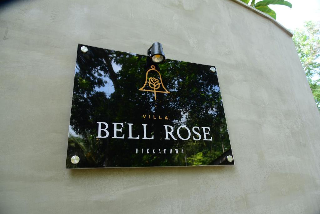 a sign hanging on the side of a wall at Villa Bell Rose Hikkaduwa in Hikkaduwa