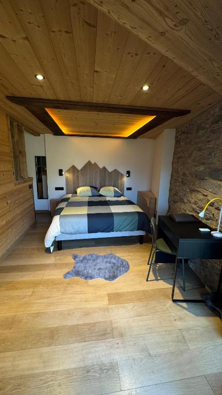 une chambre avec un lit et un plafond en bois dans l'établissement Chalet Premium 10min Funiculaire Les Arcs, à Les Chapelles