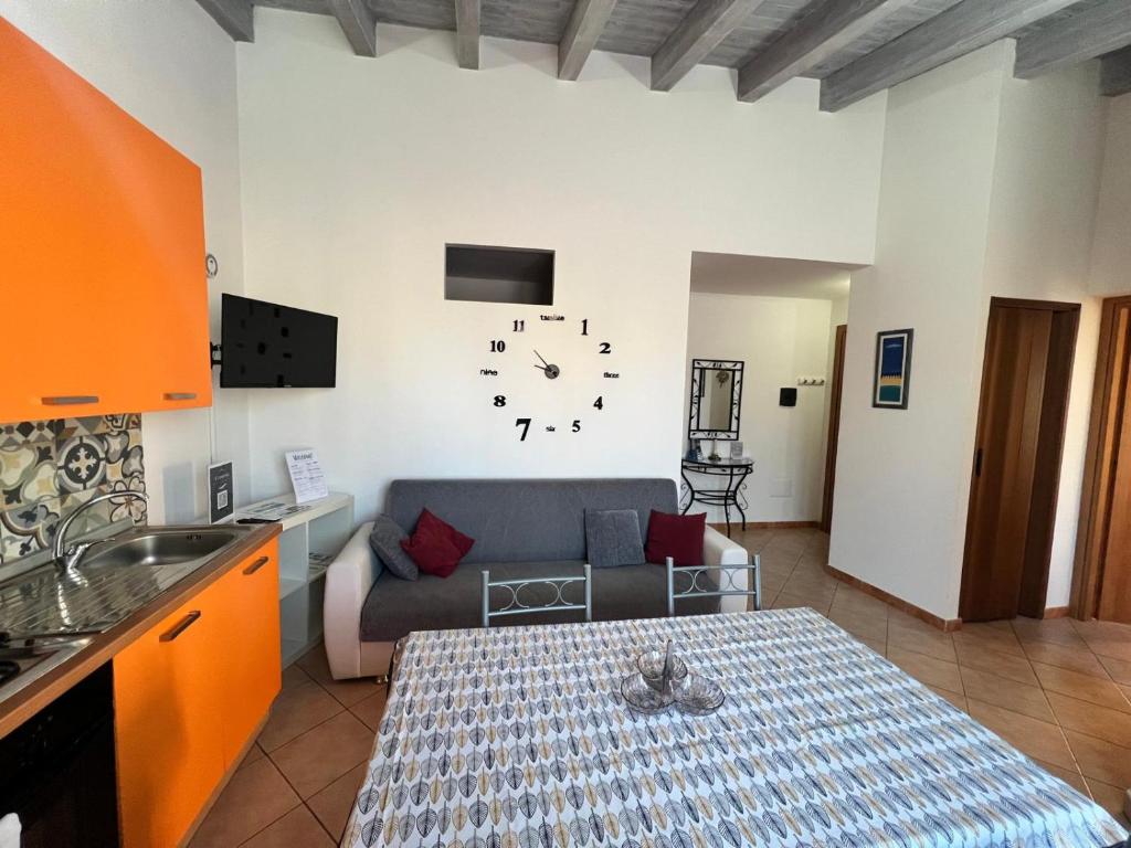 un soggiorno con un divano e un orologio a parete di Casa Vacanze A' Lanterna a Licata