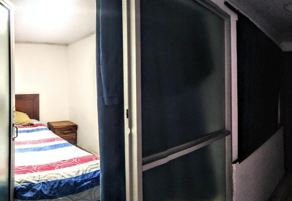 a bedroom with a bed and a sliding glass door at My second house in Manizales