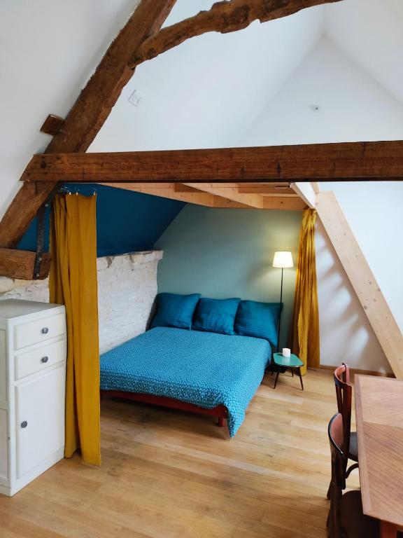 - une chambre mansardée avec un lit bleu dans l'établissement Agréable maisonnette en duplex, avec patio proche mer, à Lion-sur-Mer