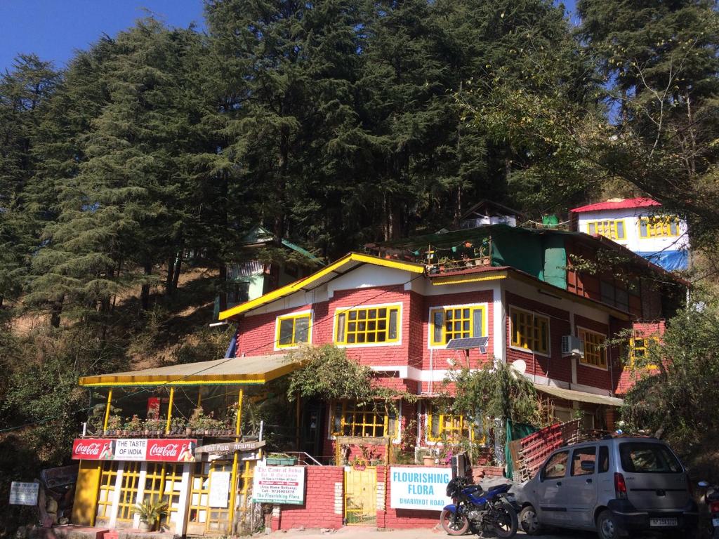 a house on a hill with cars parked in front at Mcleodganj Bed & Breakfast in McLeod Ganj