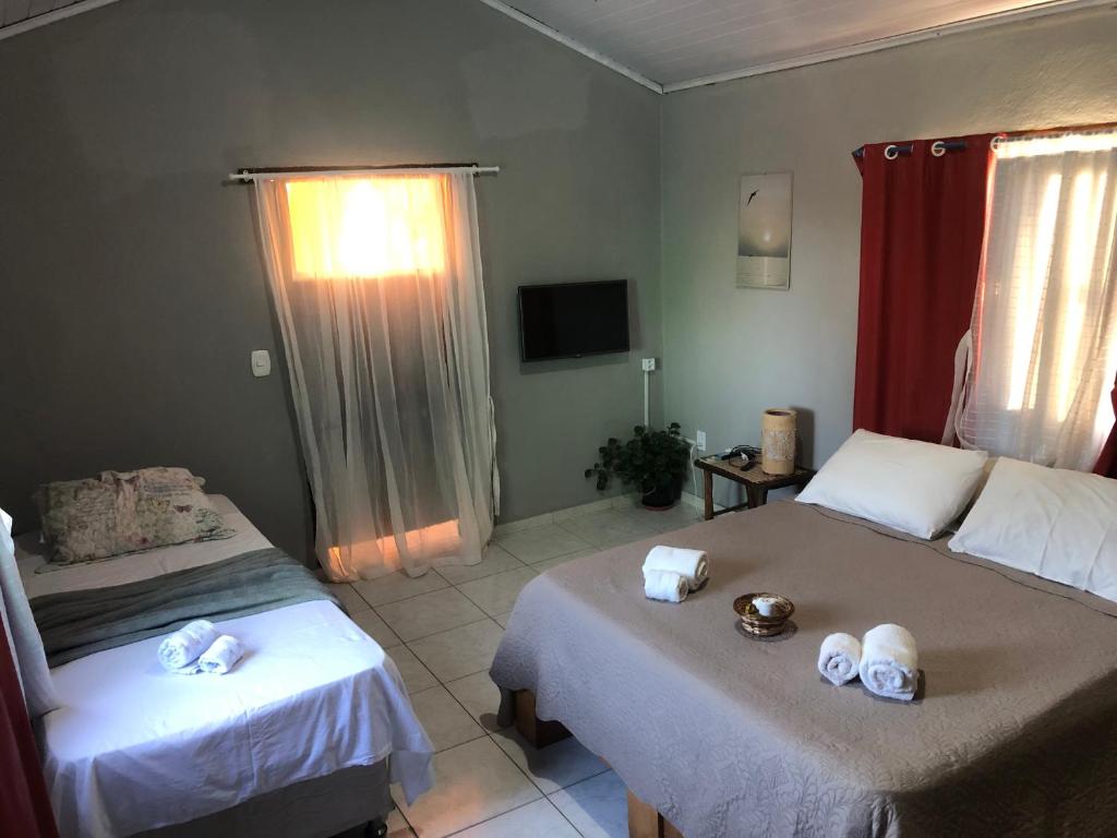 una camera da letto con due letti con asciugamani sopra di Casa Privativa em Arraial d'Ajuda - 1 Quarto com 2 camas, Cozinha e Banheiro - 10 Minutos do Centro a Arraial d'Ajuda
