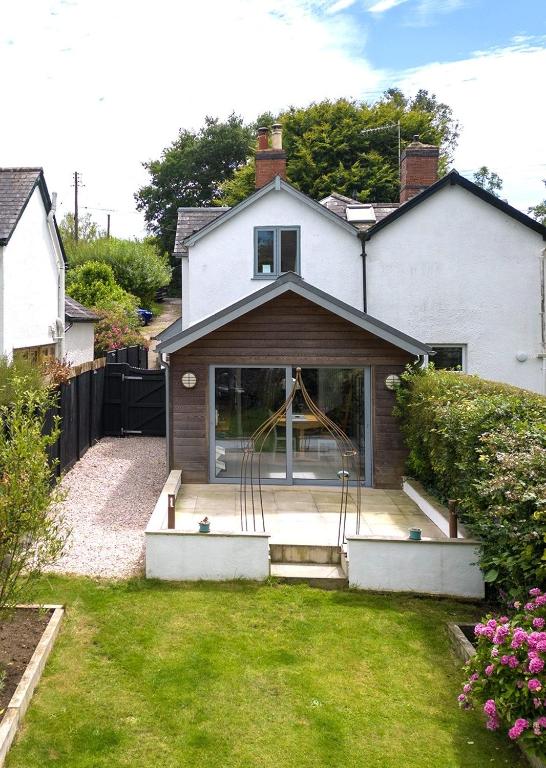 a house with a sliding glass door in a yard at Quiet Devon Luxury Escape 3-Bed in Honiton