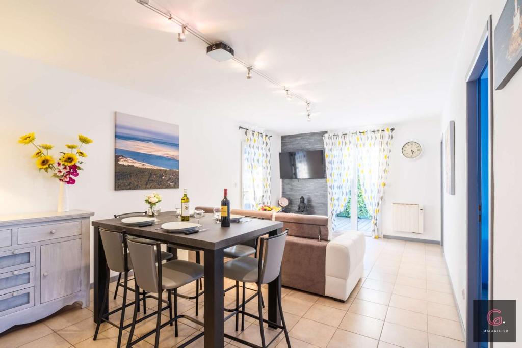 une cuisine et un salon avec une table et des chaises dans l'établissement Biscarrosse Bourg, jolie petite maison pour 4 personnes avec Terrasse et jardin, à Biscarrosse