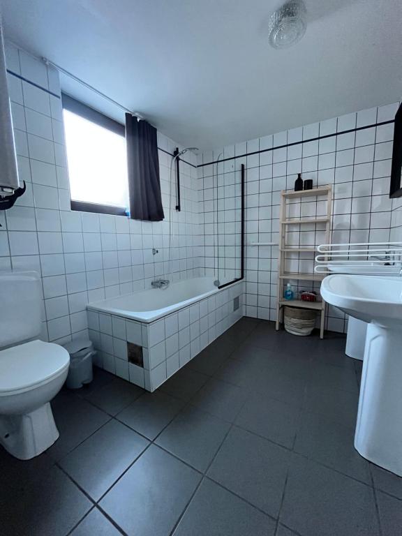 a bathroom with a tub and a toilet and a sink at Maison des M in Houffalize