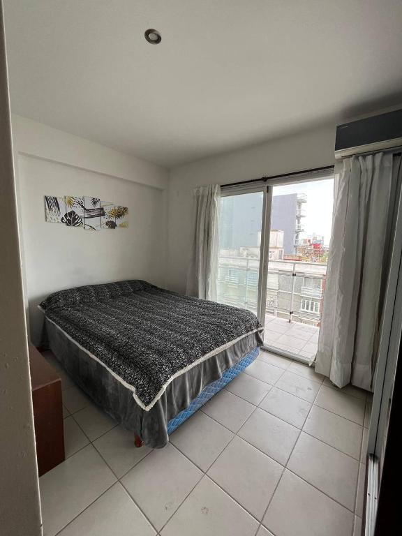 a bedroom with a bed and a large window at Colibri MDQ in Mar del Plata