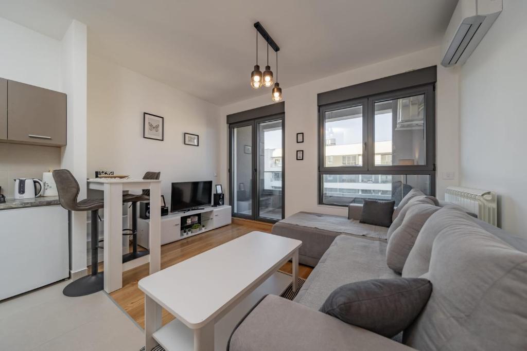 a living room with a couch and a table at Vozdove Kapije Belgrade Apartment Studio in Voždovac