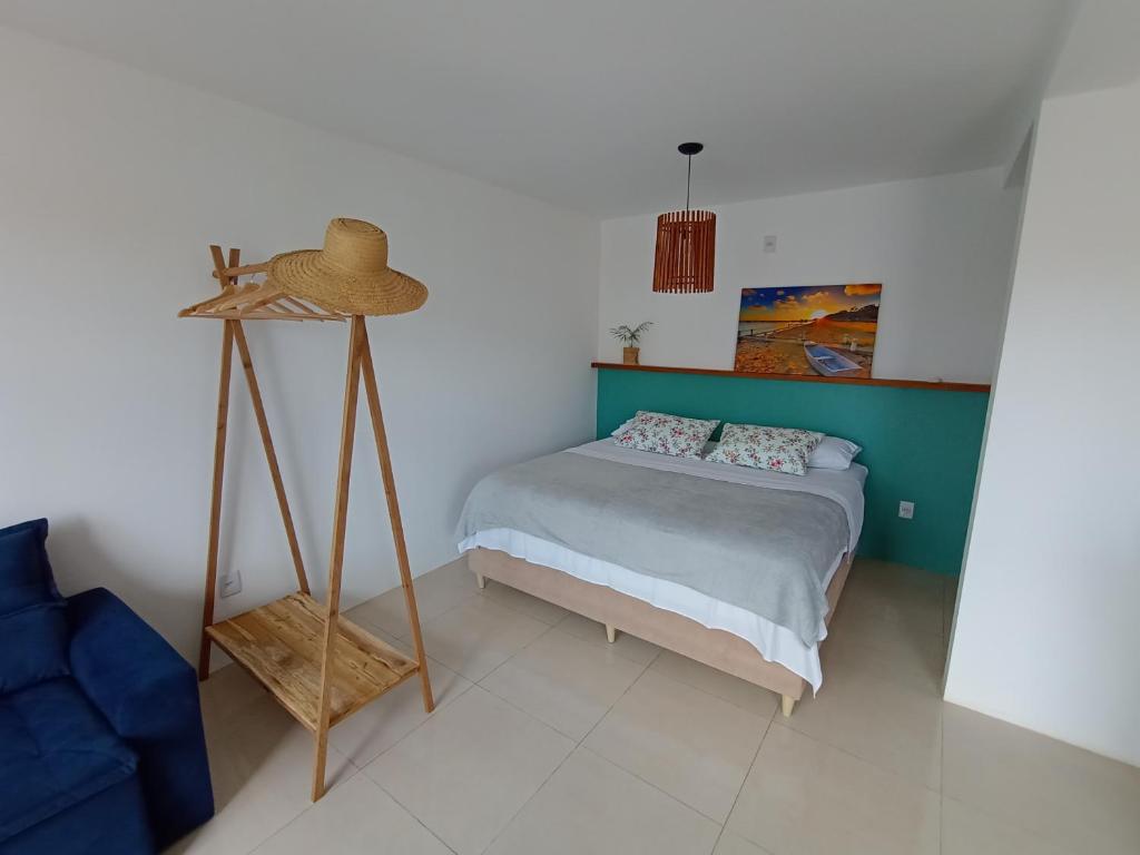 a bedroom with a bed with a hat on it at Nalu in Passo De Torres