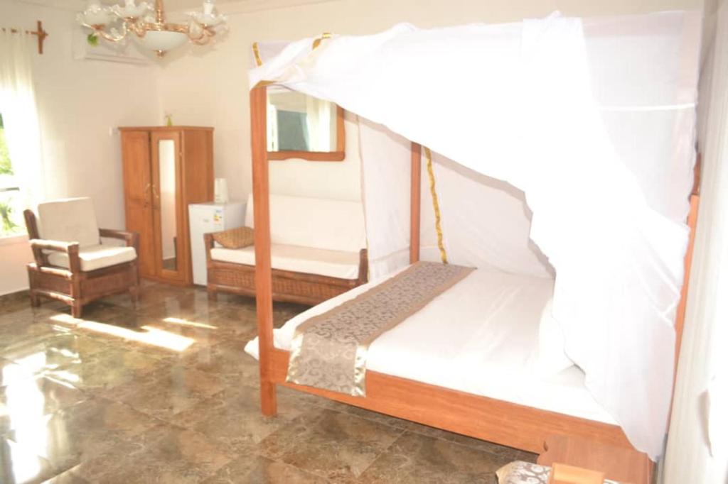 ein Schlafzimmer mit einem Etagenbett und einem Stuhl in der Unterkunft Château MBeka'a Paris in Kribi