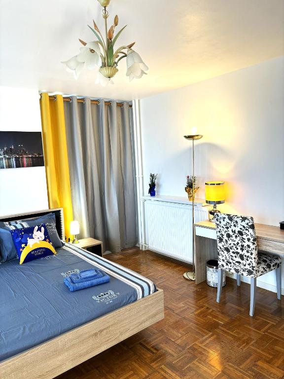 une chambre avec un lit, un bureau et une chaise dans l'établissement Grande Chambre ARENA, à Paris