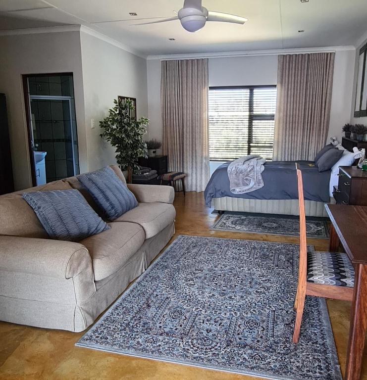 a living room with a couch and a bed at Upstairs R-1 Self-Catering Unit in White River