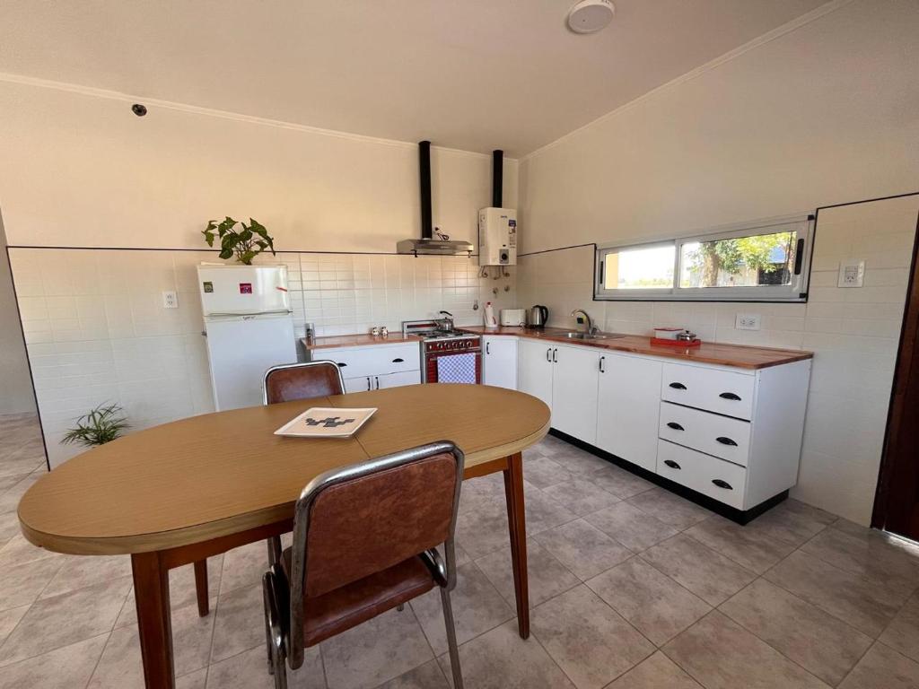 Una cocina con una mesa de madera y una mesa y sillas. en La Morenita, en Colonia Hughes