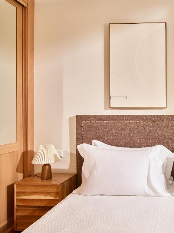 a bedroom with a white bed with a lamp on a table at Apartamentos Turísticos Casa de La Borrega in Estepona