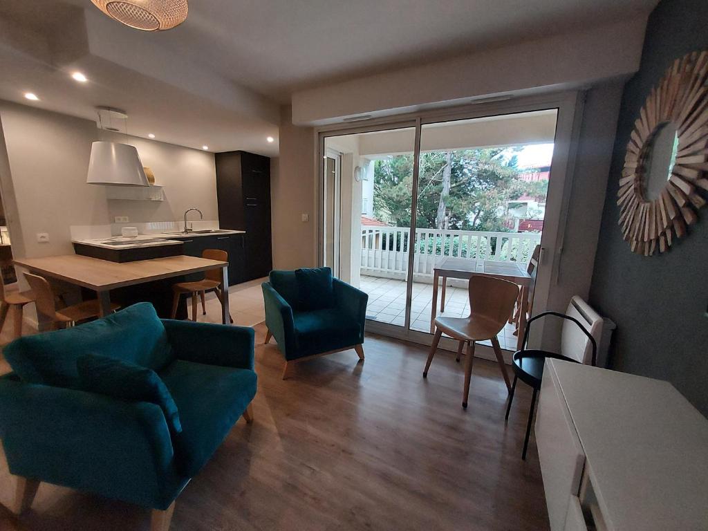 un salon avec une table et des chaises et une salle à manger dans l'établissement Résidence ERMITAGE. Appartement pour 4 personnes au centre-ville d'Hossegor. Wifi gratuit, à Soorts-Hossegor