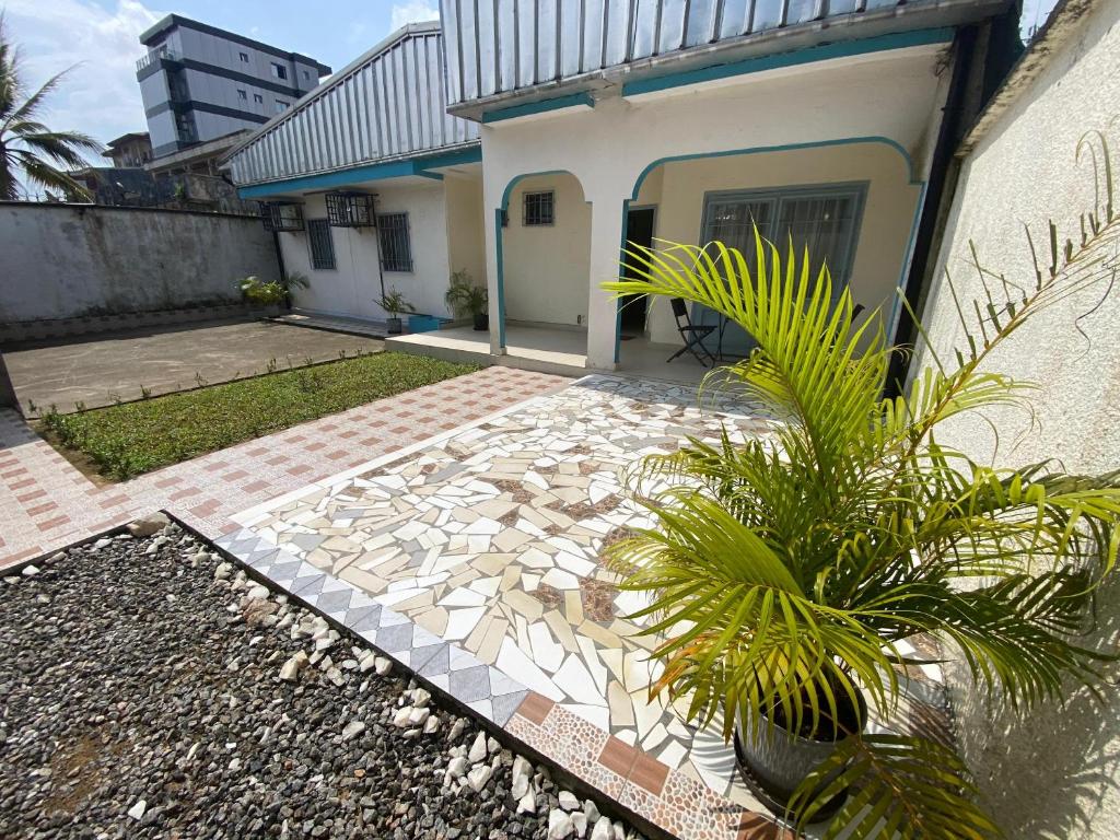 a house with a stone walkway next to a building at La-Villa-m Douala in Douala