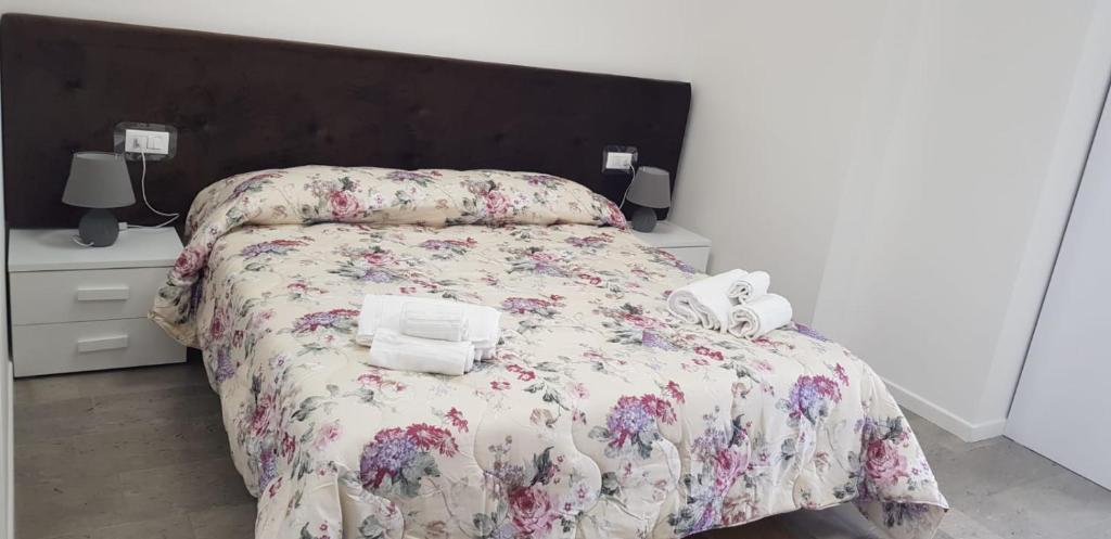una camera da letto con un letto con un copriletto floreale e due asciugamani di B&b BorgoVenezia a Scorzè